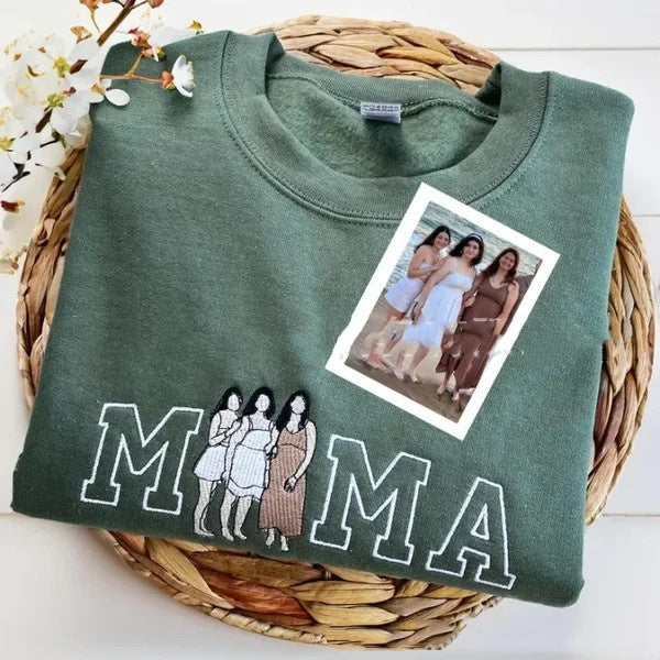 Green sweatshirt with 'MAMA' text and a photo of women on a woven mat.